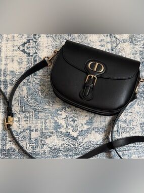 Black Leather Saddle Crossbody with Gold Accent not authenticated